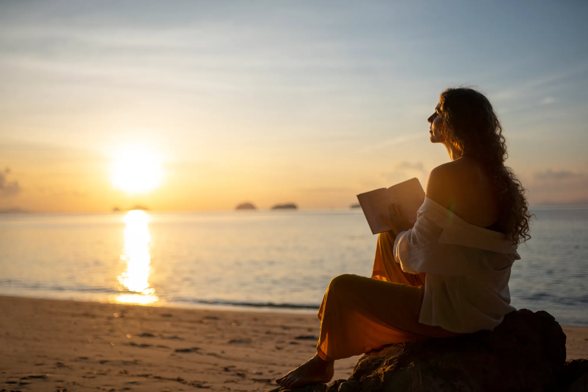 Lady reading while getting sunlight on the beach